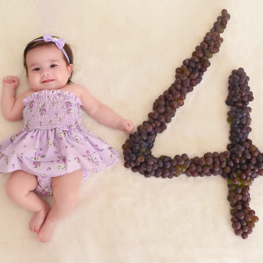 Olívia ao lado de um número feito de uvas