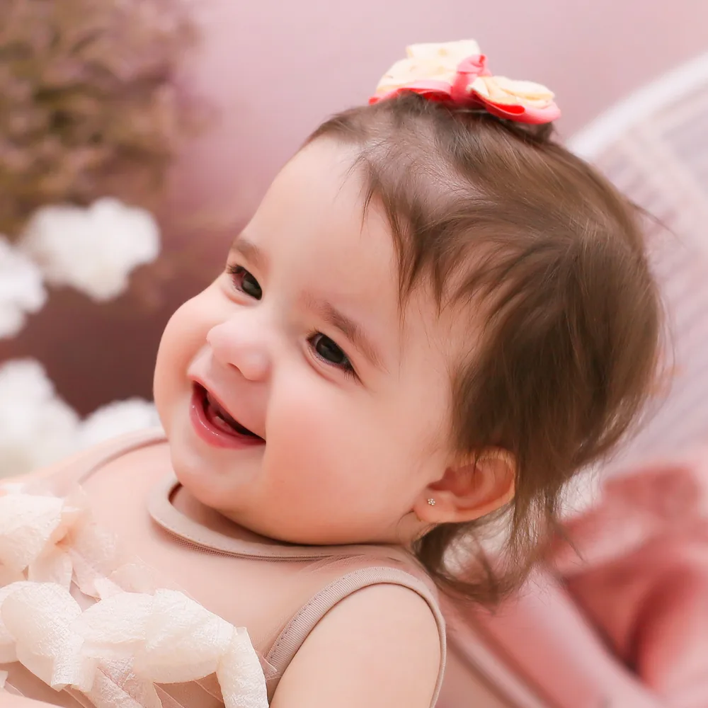 Olívia sorrindo, de laço na cabeça
